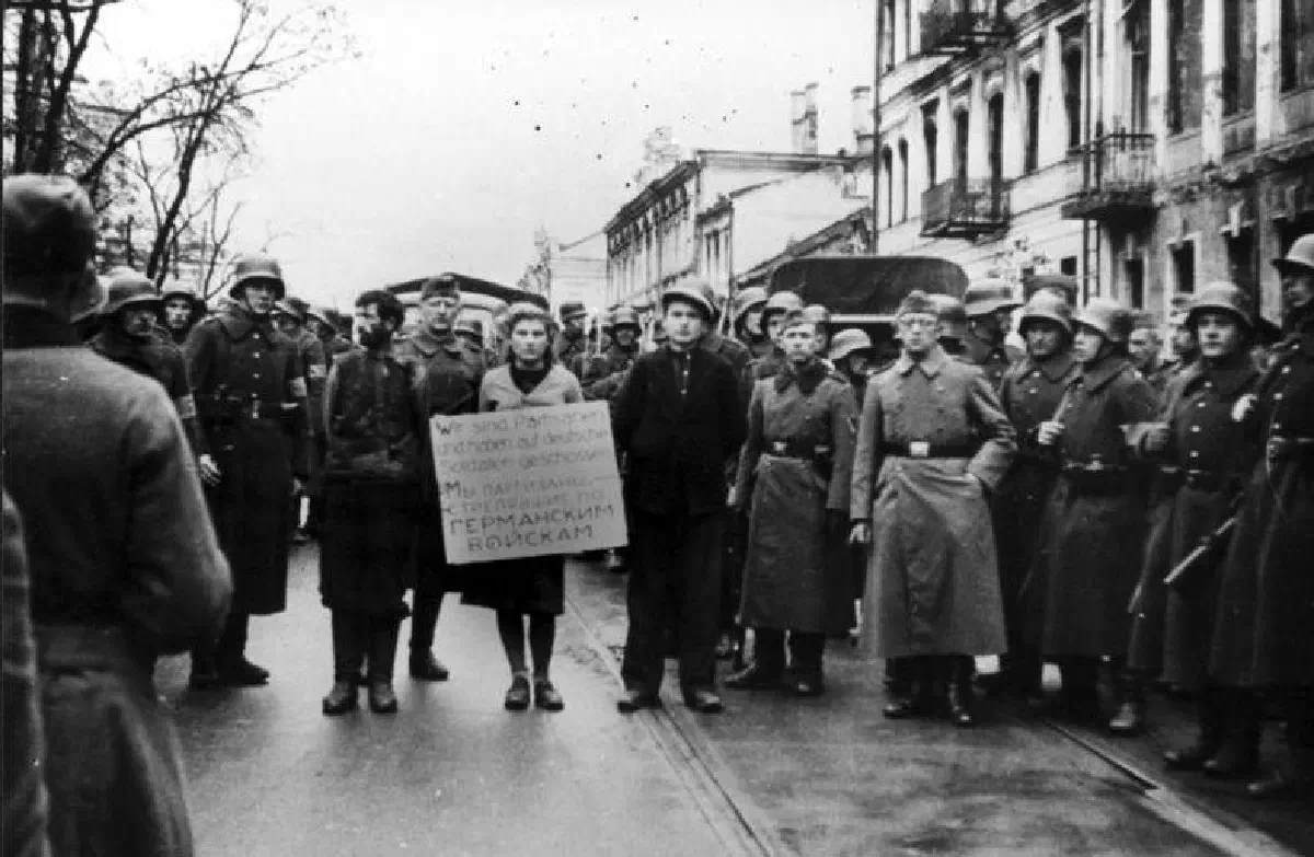 Партизаны на пути к расстрелу. Надпись на табличке: «Мы партизаны и стреляли по немецким солдатам» / Изображение: общественное достояние.