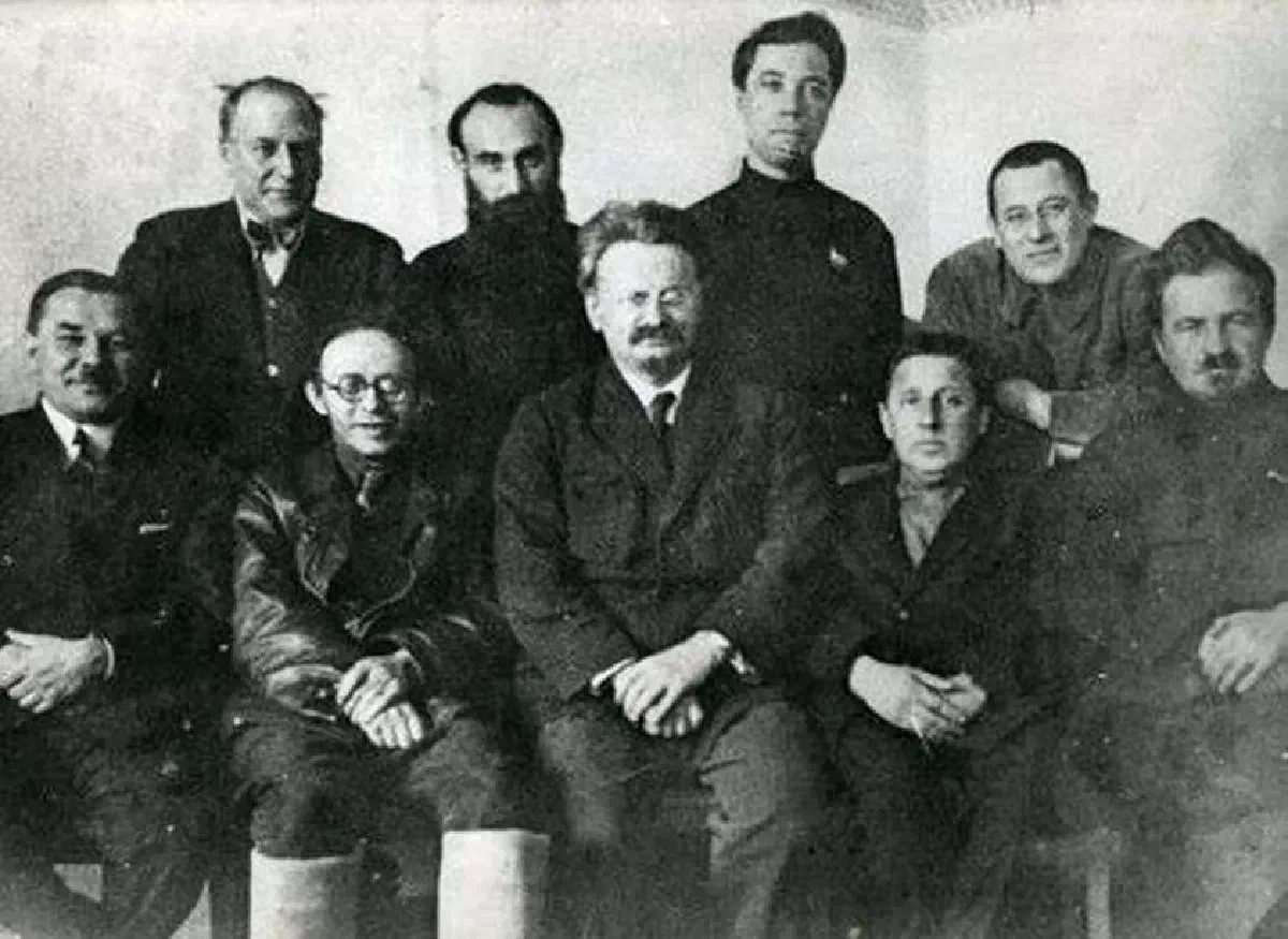 Лидеры оппозиции в 1927 году незадолго до их высылки из Москвы. Сидят слева направо: Леонид Серебряков, Карл Радек, Лев Троцкий, Михаил Богуславский и Евгений Преображенский; стоят: Христиан Раковский, Яков Дробнис, Александр Белобородов и Лев Сосновский.